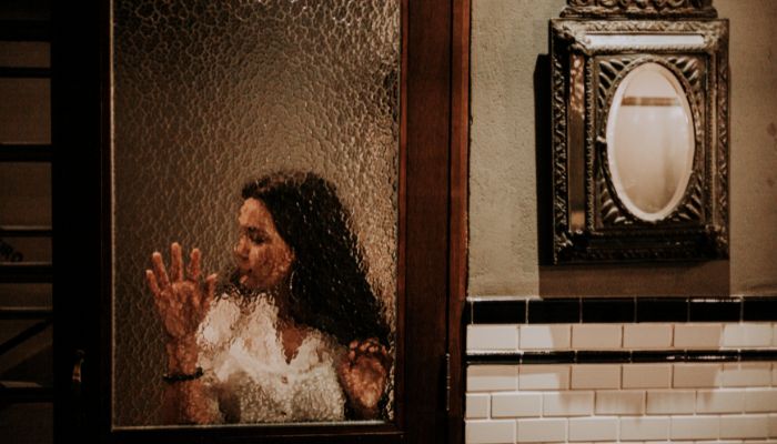 Woman Hiding Behind Glass Door